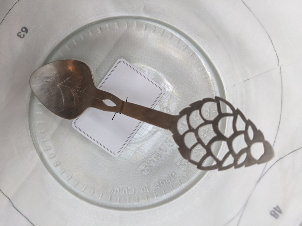 Ein Silberlöffel liegt auf einem Glas