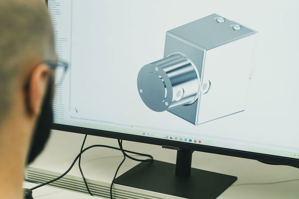 Mann vor Bildschirm mit Designprogramm
