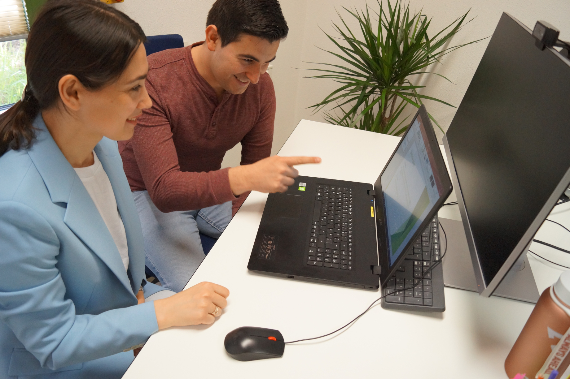 Zwei Personen vor einem Laptop
